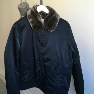 Tommy Hilfiger bomber med fuskpäls - Helt oanvänd blå Tommy hilfiger bomber jacka med grå fuskpäls. 