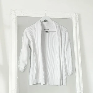 Vit kofta xs - Färg: vit.  Strl: XS.   Fin kofta från H&M. Trekvarts ärm. Öglor i varsin sida för skärp. Använd vid 1-2 tillfällen endast. Frakt tillkommer, betalning via swish.