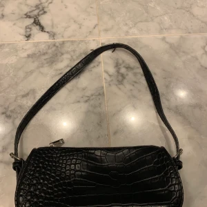 Nelly väska  - Svart väska i krocko, något sliten i handtaget (se bild)