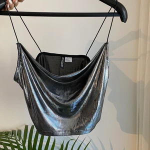 Festlinne - Supersnyggt oanvänt festlinne i skimrande tyg. Fin urringning som faller jättefint över bröstet.  Kampanj: KÖP 3 BETALA FÖR 2