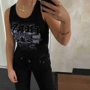  - En skit snygg svart body med ett lila tryck. Fint skick, aldrig använd. Prislappen sitter kvar 