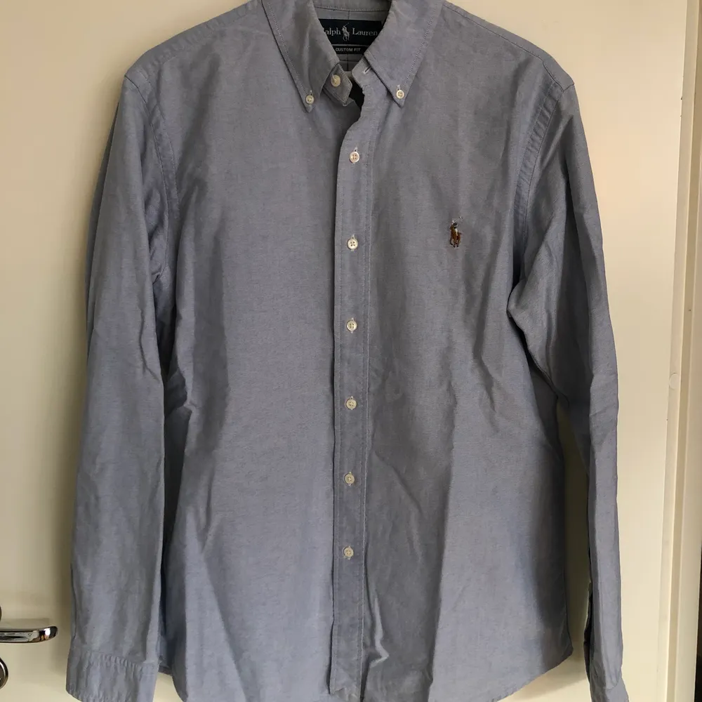 Ljusblå Oxford Skjorta från Polo Ralph Lauren. Storlek Medium - Custom fit. Använd ett fåtal gånger, men är i nyskick!. Skjortor.