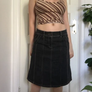 Svart jeanskjol - Svart jeanskjol med fina detaljer. Storlek 40 men sitter snyggt lågmidjad på mig med 36/38. Mellanlång. Frakt tillkommer!