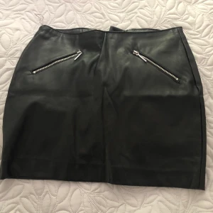Kjol i konstläder  - Kjol i konstläder från H&M i storlek 32. Känns som 34. Säljs då den är för liten för mig. Skickas mot fraktkostnad- kan samfrakta.
