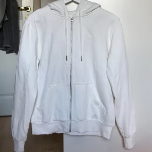 Vit zipup-hoodie - Vit zipup-hoodie med luva från hm i nyskick. Storlek M, men passar xs-m beroende på vilken fit man vill ha. Mysigt material inuti. 