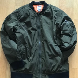 ’Bomberjacka’ - Grönsbrun, orangefoder. Schysst höst jacka. Oanvänd. 14-16 år