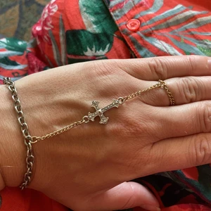 Så fett handsmycke goth  - Så snyggt handsmycke med kors. Reglerbar längd mellan 17-20 cm. Ringen är en kedja ca 17 mm. Buda gärna. Frakt 15kr. 