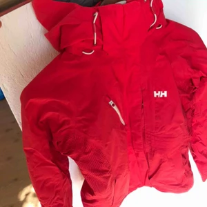  - Helly Hanson Jacka.  Fint skick. Använd på en skidresa.  Baywatchröd.