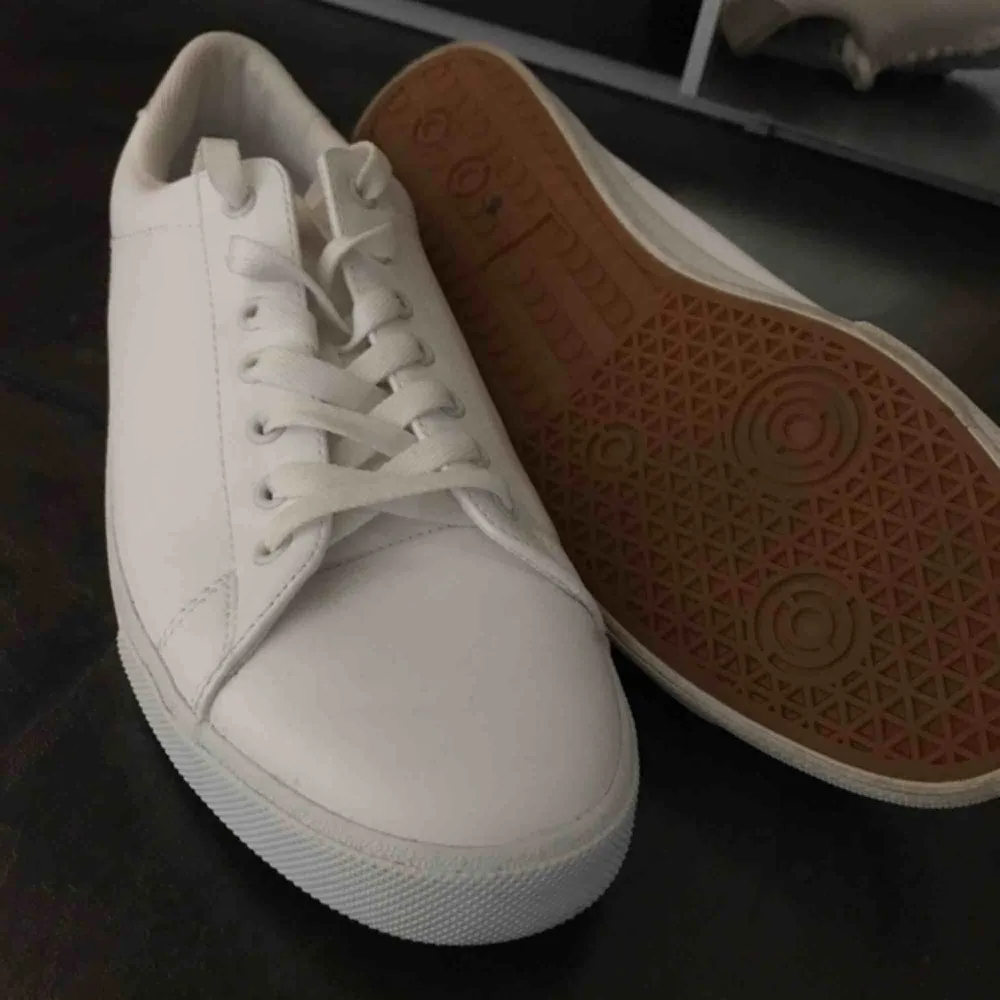Ett par sprillans nya skor från H&M som endast är använda en endaste gång!  Helt vanliga vita sneakers som passar till många olika klädstilar. Skor.