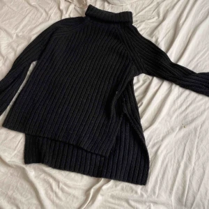  - Stickad tröja med slits, längre bak en fram. Storlek S