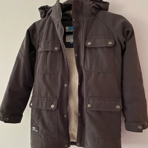 Warpjacka stl 128 - Fin och varm höst/vinterjacka med ”päls”foder i stl 128. Från Warp. Kommer från djur- och rökfritt hem. Frakt tillkommer!