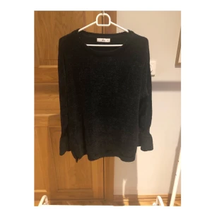 Svart tröja i velour - Svart tröja i velour med volang ärm. Använd 1 gång. Är strl. XS men är som en S. Finns att hämta i Lund eller skickas, men köpare står för frakten.