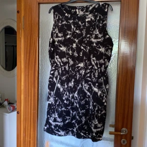 Spräcklig klänning strl. XL - Svart/vit spräcklig klänning i strl. XL med dragkedjefickor. Pris exkl. frakt, köparen står för frakten.