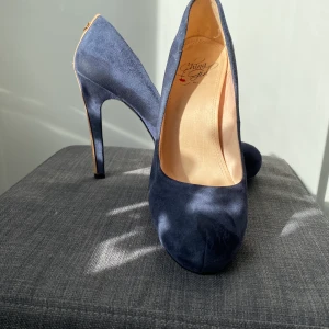 Blå pumps  - Blå pumps med beige lackrand på klacken. Lite platå vid tårna. I mockaliknande material. 