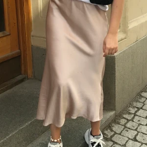 Satinkjol - Puderrosa satinkjol från asos. Slutar nedanför vaden på mig som är 171cm. Säljes för 100kr!