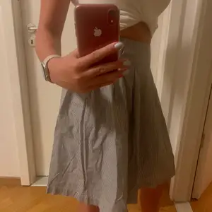 Supersöt knälång kjol från okänt märke (frk.) i strl 38 säljs då den är förstor för mig. Den är i skjortmaterial med små små ränder i vit och mörkgrå/svart. Pris exkl frakt