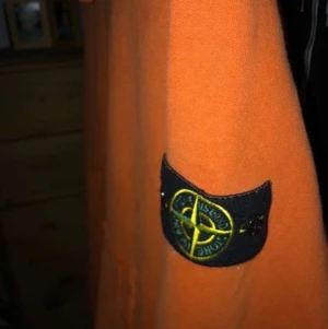 Stone island hoodie - En orange stone island hoodie i storleken S. Säljer eftersom jag inte använder. Fint skick. Köp för 2500kr säljer för 1900kr. Kan mötas upp i Stockholm eller så står du för frakt.