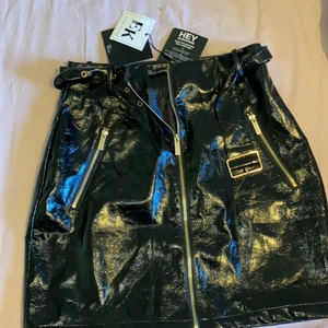 Skinn / latex kjol  - Skit snygg med svagt guld detaljer och skärp, jag har strl 34/36 den passar om man spänner åt skärpet annars är det strl 38. Alla lappar kvar helt ny och oanvänd från Nly trend x Erica kvam kollektionen. 150 eller högsta bud