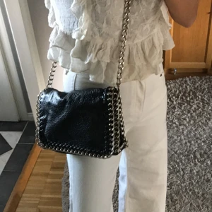 Läderväska - Väska som känns som äkta läder/skinn men vet inte om det är det. Tjockare silverskedja. Fack inuti. 
