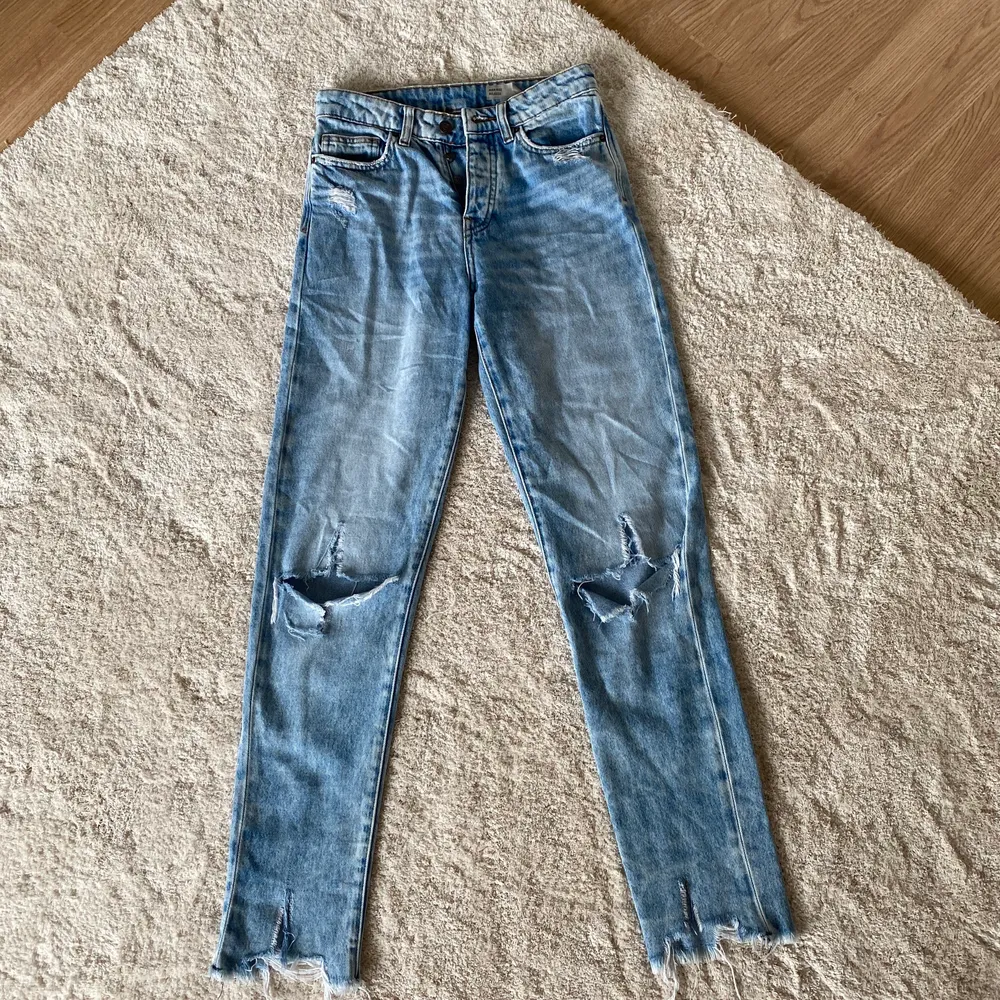 Blåa högmidjade jeans från Vero Moda med hål i knäna, jag köpte de utav en annan tjej men dom passade tyvärr inte :/ Jag har aldrig använt och tjejen innan hade använt de ett fåtal gånger! Jättefint skick. . Jeans & Byxor.