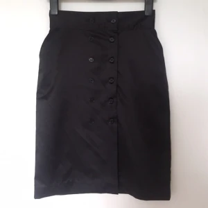  - Fin kjol i satin med knappar och hög midja. +28 för frakt 