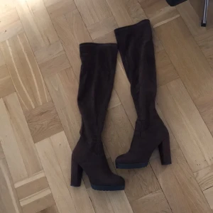  - Supersnygga over knee klackskor i mörkbrun färg. Materialet är en mockaimmitation. Cirka 10 cm klack!
