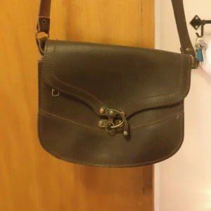  - En liten super söt vintage väska i mörkbrunt läder, en lite dragkjeda på både insidan och utsidan av väskan!