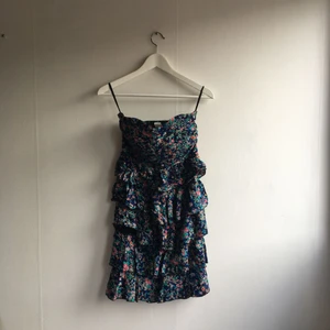  - Mönstrad klänning med volang nertill. Aldrig använd.