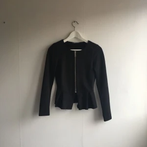  - Svart kavaj med volanger nertill. Använd ett fåtal gånger.