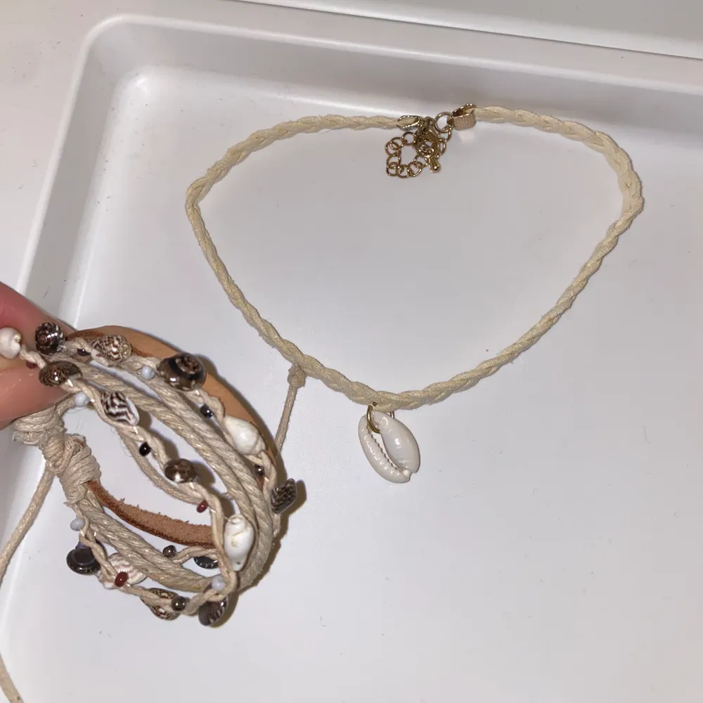 Smyckes sätt ett armband och ett halsband som matchar varsnades jätte fint, båda är handgjorda har snäckor flätade och är i färgen vit, bege, brun. . Accessoarer.