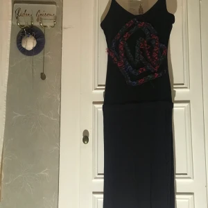 Designad klänning  - Bekväm figursydd men annorlunda klänning som framhäver fina former, bottendöden är mörk blålila och toppen svart.