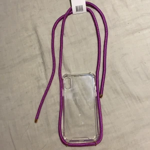 IPhone X mobilskal  - Ett IPhone X mobilskal som har snören att hänga runt halsen så att den inte tapas.