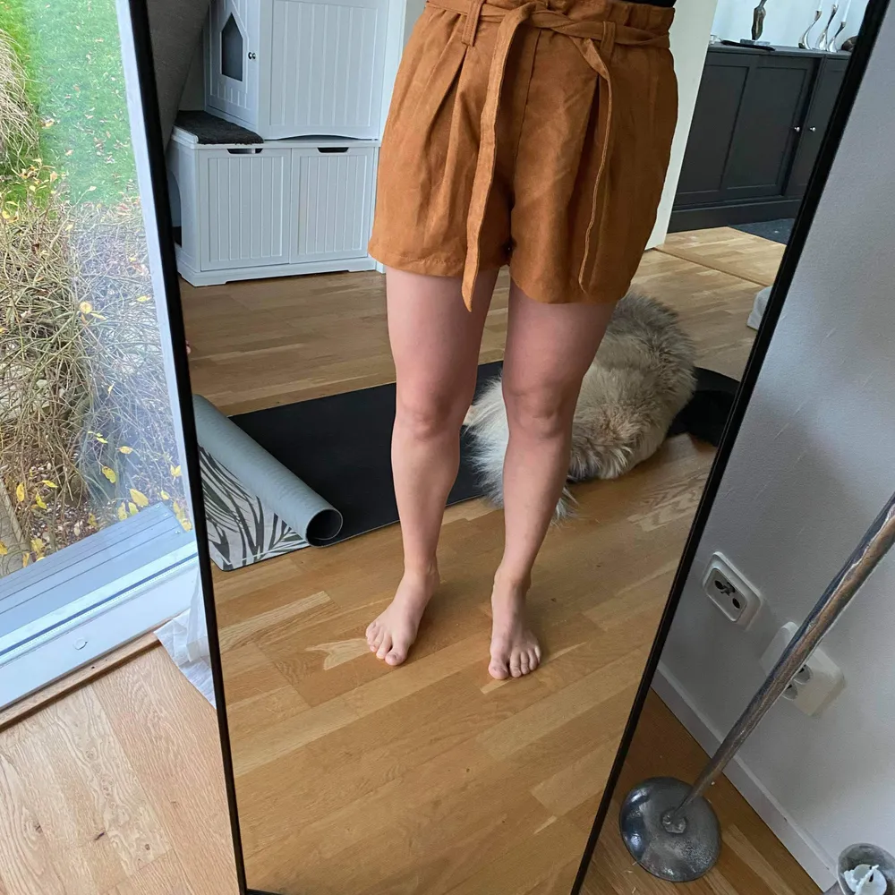 Mörkt orangea shorts i mockaimitation (100% polyester) som knyts med midjeband. Jättebra skick, knappt använda. Ganska stora i storleken, passar 38a.. Shorts.