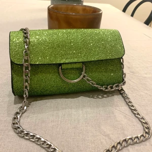 Grön glittrig handväska - Snygg grön glittrig handväska från Nelly. Sparsamt använd! Frakt på 63kr