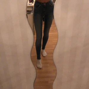 Blåa jeans - Blåa högmidjade jeans från bikbok. Aldrig använda.