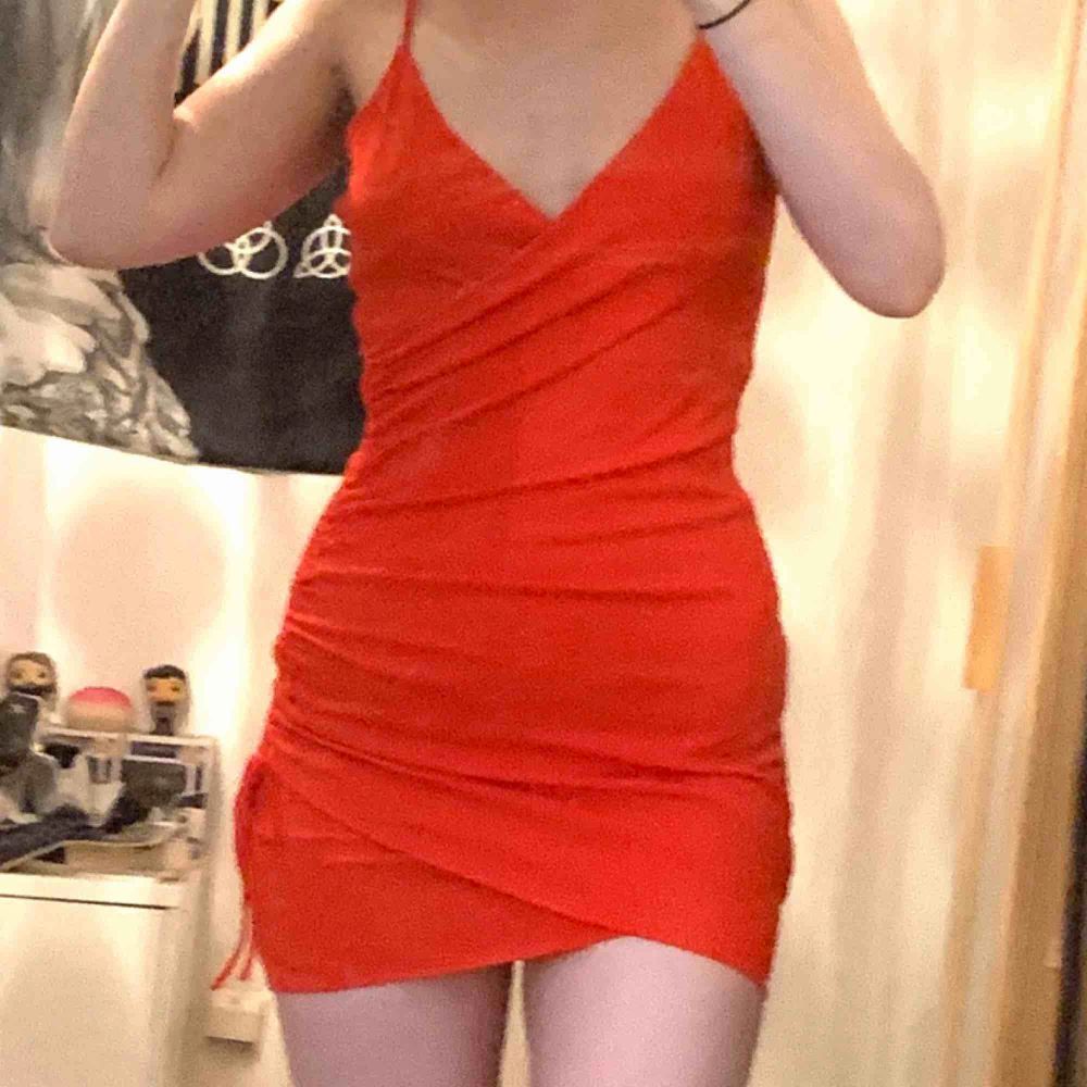 Röd, tight klänning från H&M med spaghetti straps och rysch på sidan. . Klänningar.