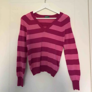  - V-ringad, långärmad tröja från united colors of benetton. Tröjan är randig med mörkrosa samt ljusare rosa. Nästintill aldrig använd. Nypris, cirka 500kr. 