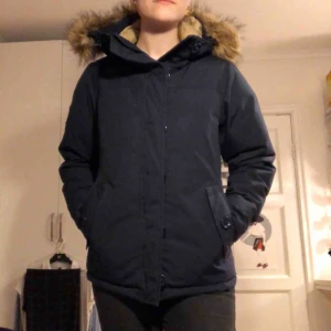  - Superfin dunjacka i äkta fun från märket Race marine. Knappt använd då den var köpt en vinter som var för varm och hann sedan växa ur den. Superfint skick! Marinblått tyg och luva med fuskpäls
