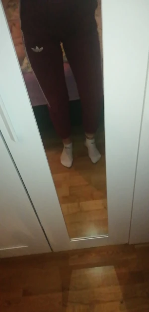 Adidas byxor i bra skick  - Ett par Adidas mjukis i vinröd färg med vita detaljer på sidan, då de är använda fast i bra skick fortfarande, storlek S fast passar M lite bättre. Man kan ochså skystera vid magen, jag säljer då de är lite korta för mig