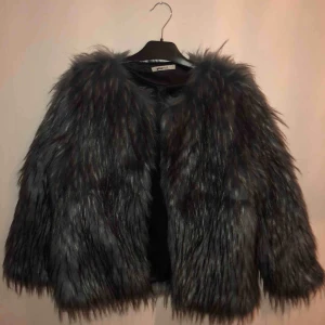  -  En blå/svart fuskpälsjacka med en ficka på vardera sida. Använd ca 3 gånger och är i lika fint skick som när jag köpte den. 