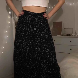  - Lång svart kjol med vita prickar o slits, använda fåtal gånger. Köpt på ASOS, köparen står för frakten :)