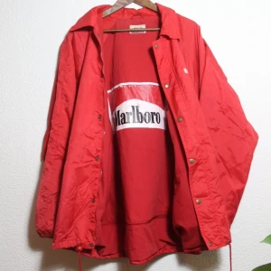 MARLBORO regn/vindjacka - VÄRLDENS COOLASTE regnjacka är nu till salu. Herr XL, men snyggt Oversize på tjej! Trycket på insidan hsr lossnat lite men vad gör det! Skriv om du vill ha fler bilder. Frakt 66kr