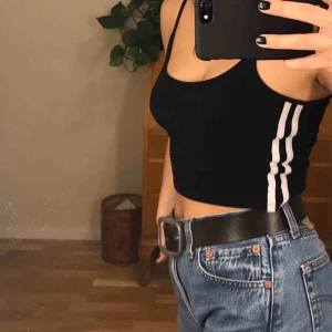  - Svart linne (magtröja) med vita sträck på sidorna ifrån Brandy Melville. Passar storlek XS. Möts i Stockholm annars står köparen för frakten😝 