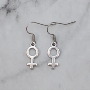 Örhänge kvinnosymbol silver  - Fina silverfärgade örhängen med kvinnosymbolen. Finns även som guldfärgade och roséguldfärgade. Nickelfria. 