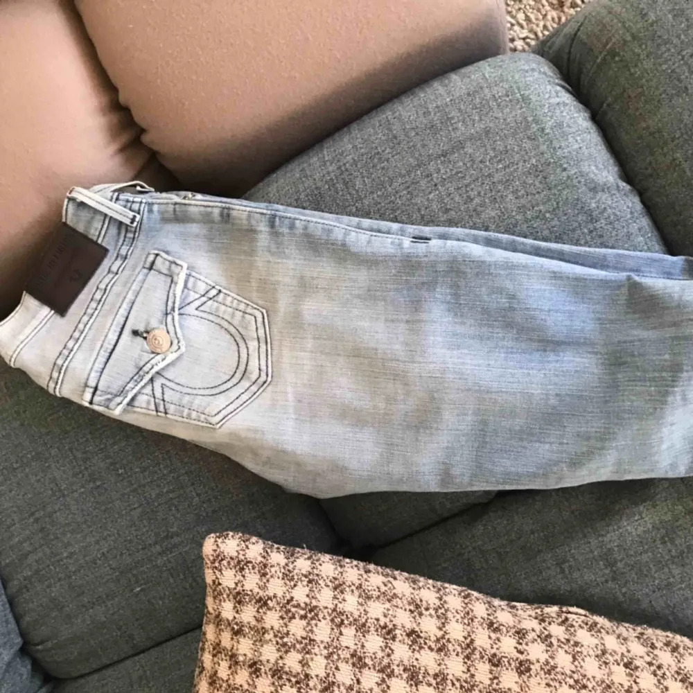 Ljusblå True Religion jeans. Lite bootcut, passar för långa kvinnor/ tjejer. Jeansen är ripped längs benen. Köpta i Miami 2016, knappt använda! Strl 25 ( väldigt mycket stretch, passar en 26/37). Jeans & Byxor.