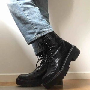  - Snygga svarta kängor i svart blankt material med krokodilskinnsmönster. Säljer eftersom jag har ett par liknande. Lite rispor på insidan av foten, men annars i gott skick. Pris går att diskutera😇