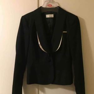  - Supersnygg och elegant svart figursydd kavaj från Esprit Urban Casual, de Corp. Fina detaljer, kolla in krage och beslag i beige siden och även hakarna längst ned på baksidan av ärm. Endast använd en gång, som ny.:-)