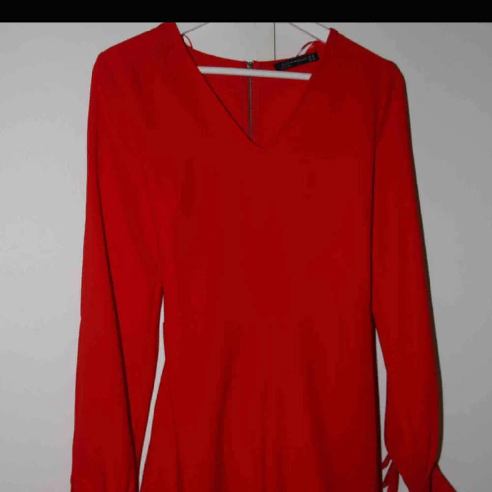 Röd/coral färgad jumpsuit från Chiquelle. Använd 1 gång. Storlek 38 (S/M). Öppningar i armarna, en mindre öppning i ryggen och rosett . Övrigt.