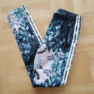  - Jättesnygga adidas byxor som tyvärr är för små. Köpte dem på plick då säljaren sa att dem inte blivit mycket använda och jag har då bara provat dem. De går att dra åt i midjan och har dragkedjor på botten av benen! Om ni vill ha fler bilder är det bara att fråga efter det.  Jag kan frakta, då betalar köparen halva frakten!