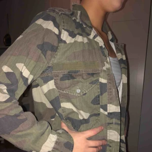  - Tunn vår/sommar jacka i militär från ginatricot. Väldigt bra skick och perfekt till vår/sommar. Två fickor där framme och knappar hela vägen